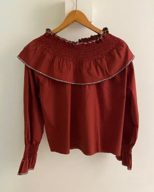 Blusa roja/burdeos de manga larga con cuello alto fruncido y volantes.